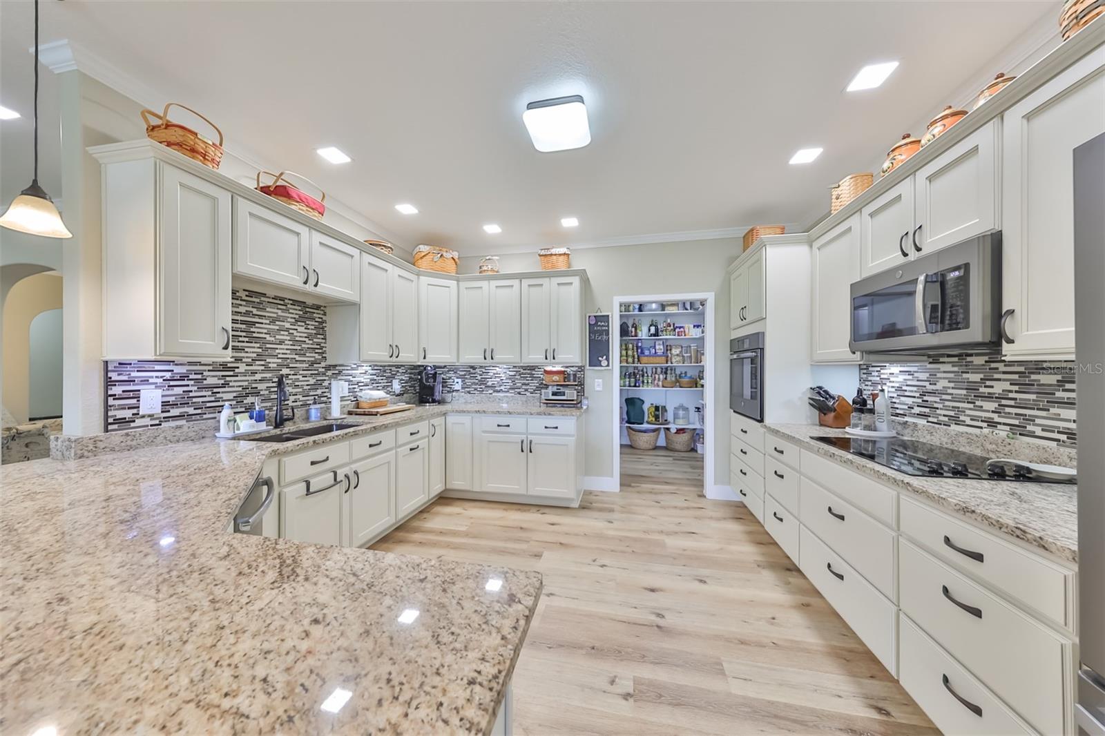 The kitchen features lots of extra cabinets for additional storage and matching flooring throughout. And on oversized pantry room with maximum storage and shelving!