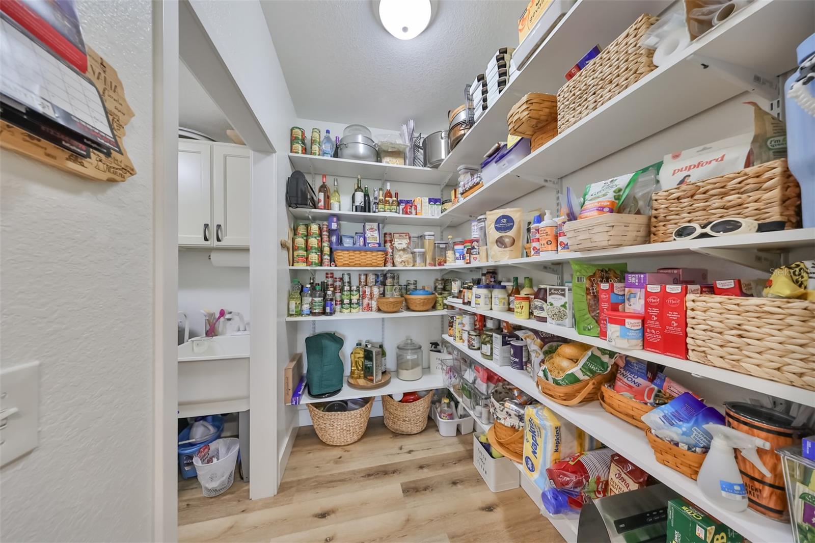 A large oversized lighted walk-in pantry room (not closet!) is attached to the kitchen and includes updated shelving, perfect for organizing and seeing all of your ingredients with ease when whipping up that next delicious meal.