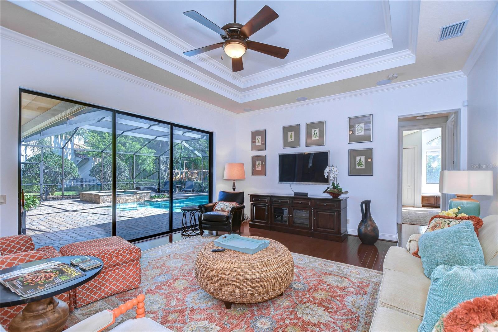 Family room features a wall of sliders, an elevated tray ceiling, and built-in ceiling speakers!