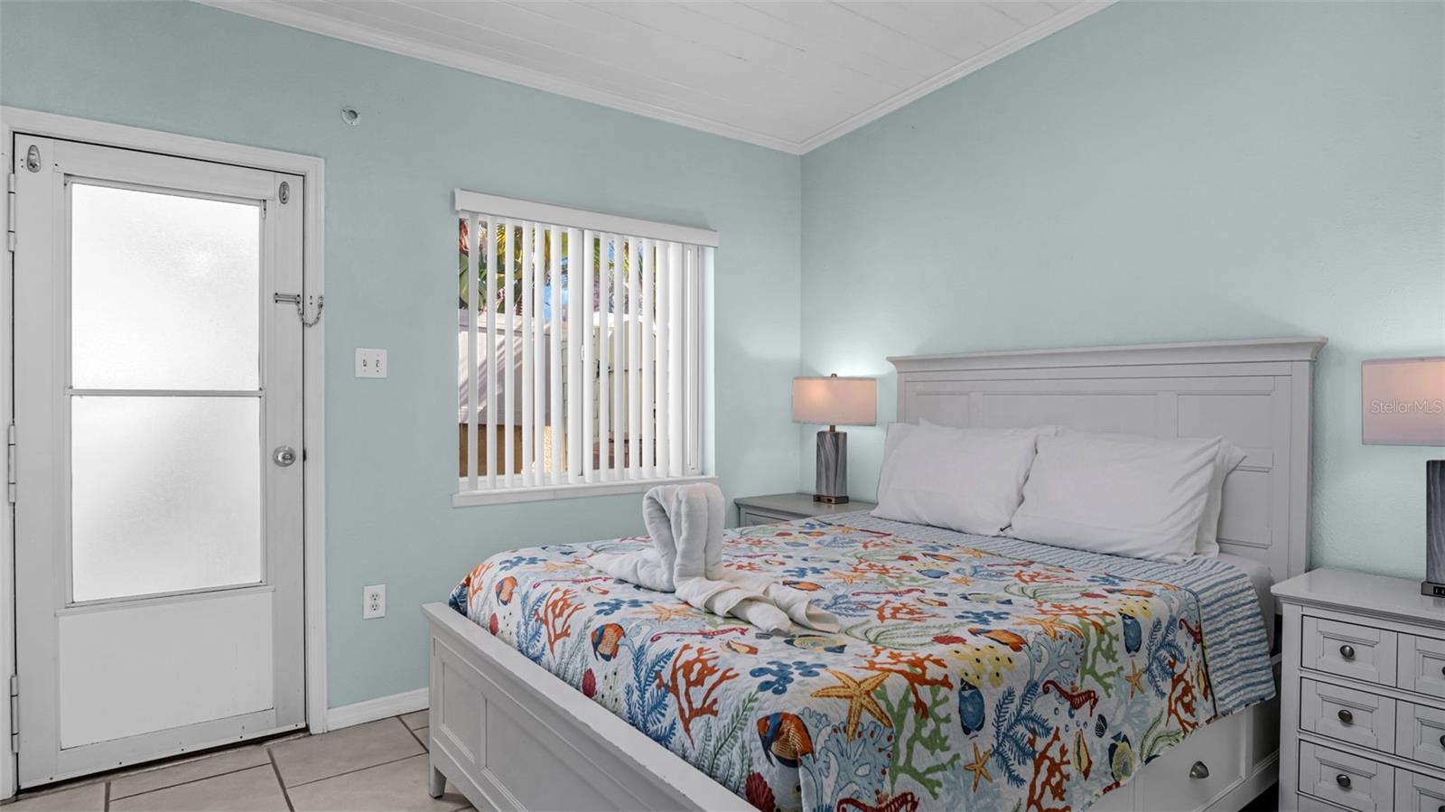 Large bedroom with exit to the backyard patio and community laundry room.