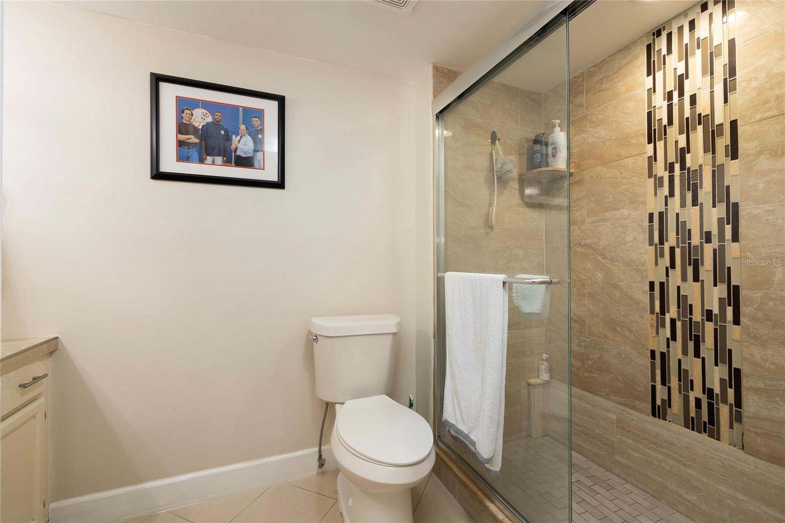 Beautiful walk-in primary shower with decorative tile wall