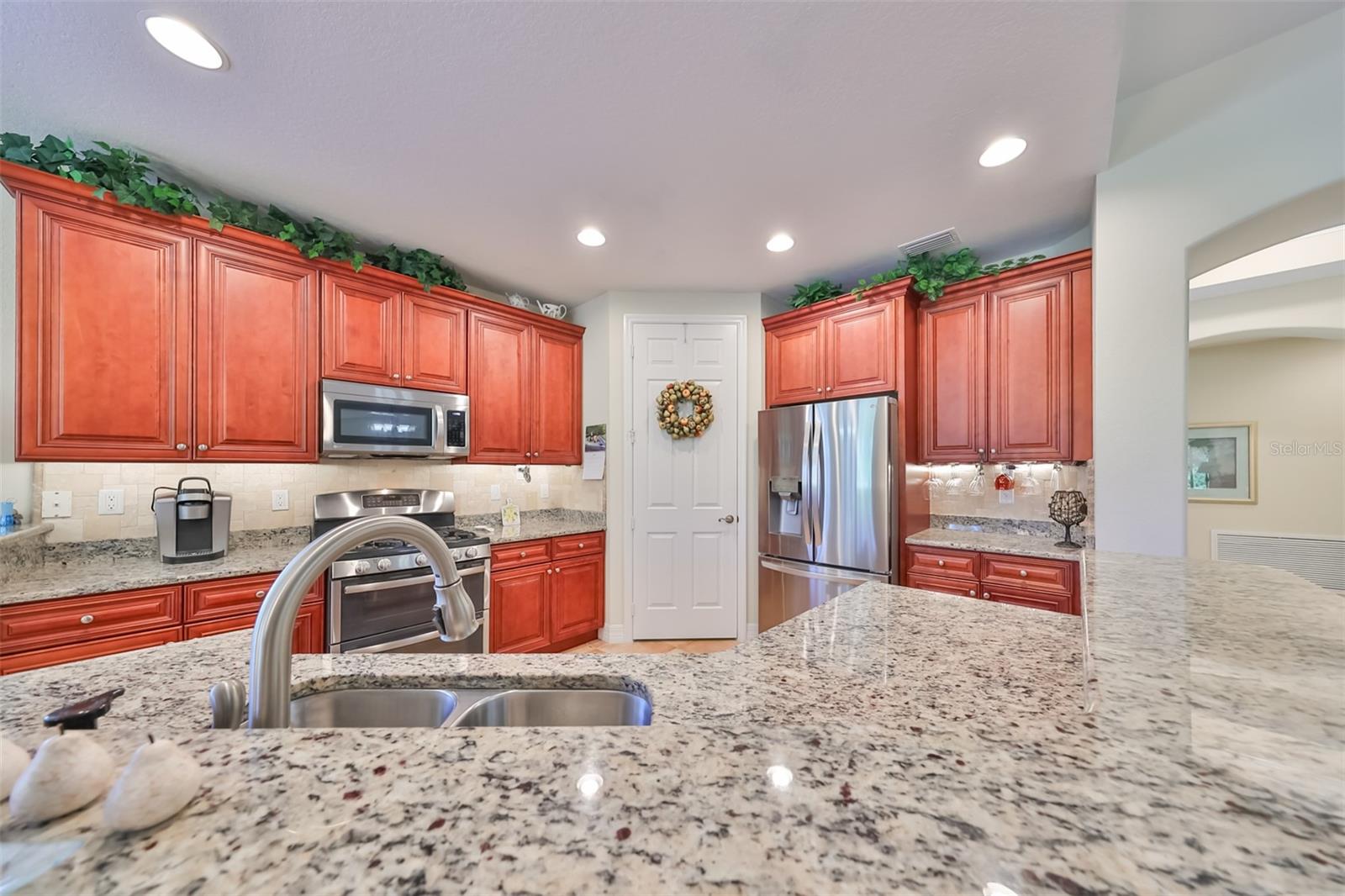 Kitchen is spacious, bright, open and inviting with an extra large counter to eat at and an undermount sink. Notice the recessed lighting in addition to the natural light that flows through the kitchen.  Lots of room for multiple cooks.