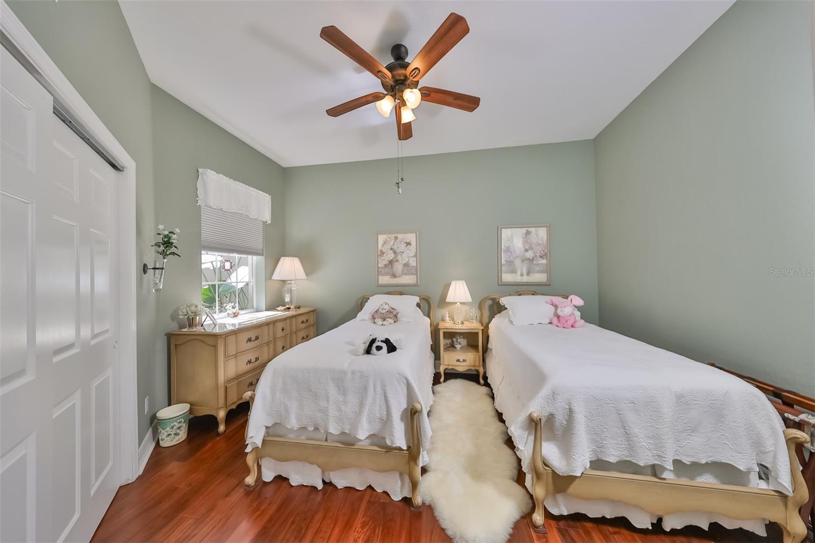 Bedroom #2 has stunning Acacia wood flooring, a large window with custom blinds and a ceiling fan.