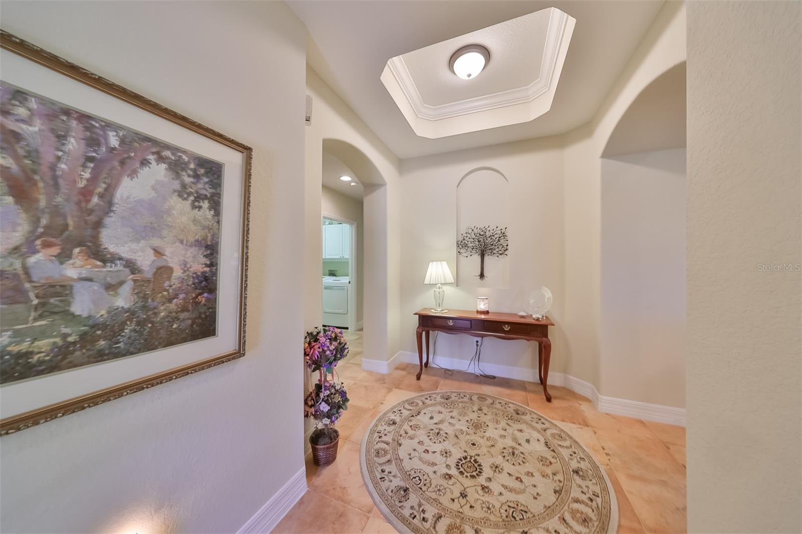 Inviting foyer entrance into this home has elegant neutral tones, tray ceilings and architectural niches.