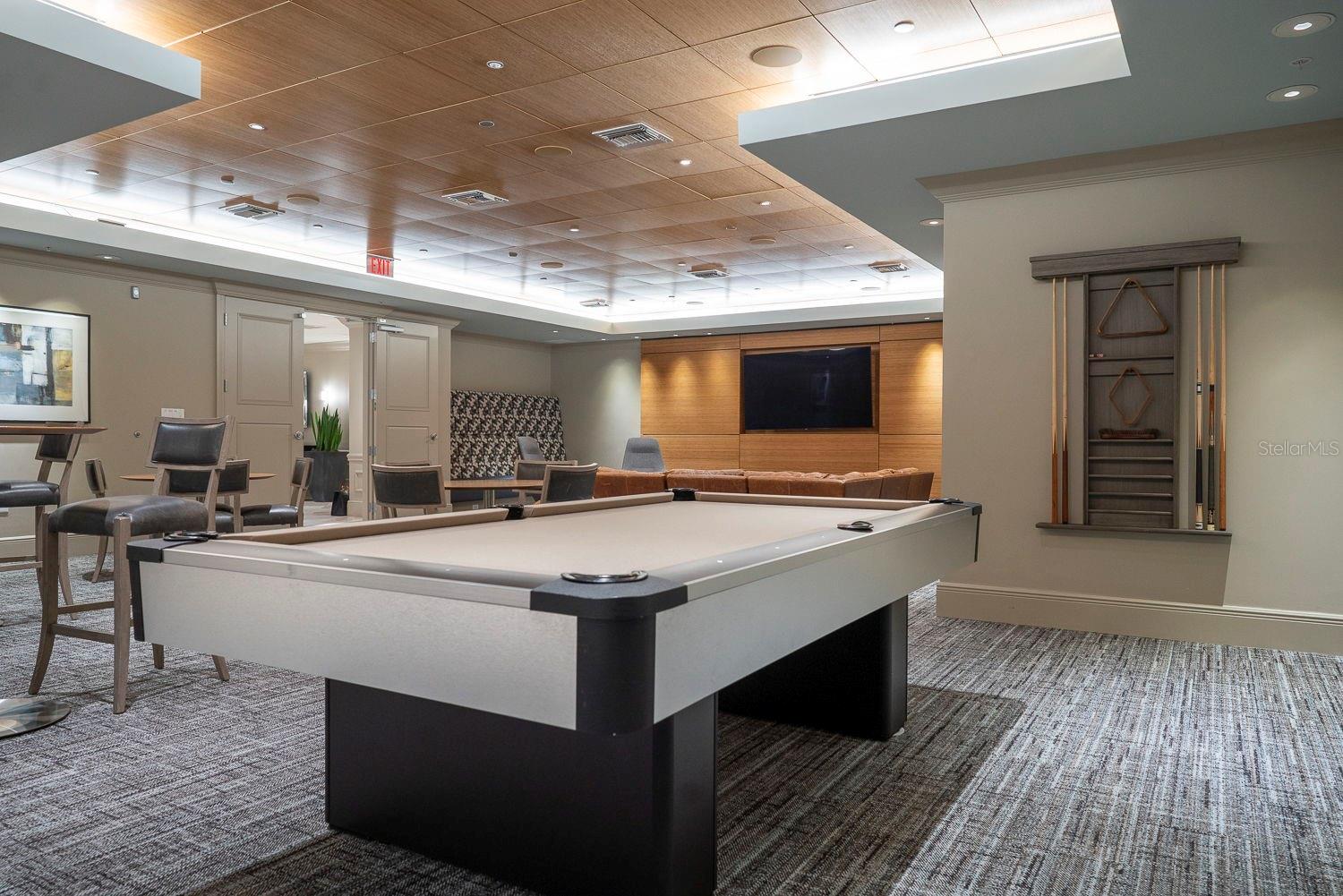 Spend time with friends and family in the entertainment room, featuring a billiards table, cafe/bar area, seating, and television.