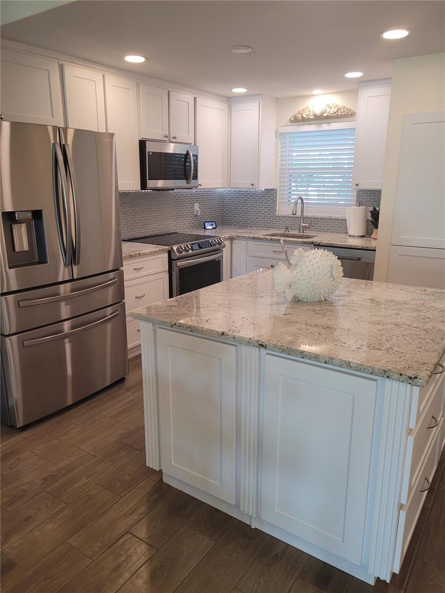 Walk in to the spacious and tastefully designed Kitchen with stainless appliances and lots of storage. On the right side is a full sized Washer and Dryer.