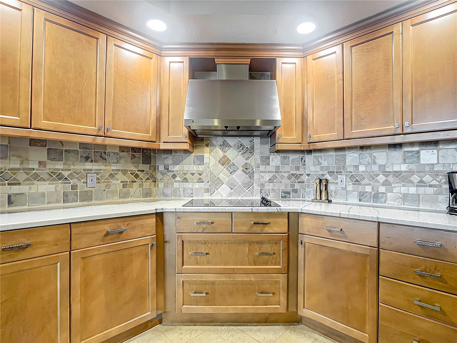 This kitchen view highlights the beautiful backsplash & the pull out drawers in the kitchen