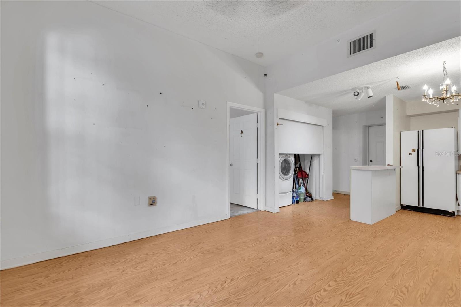 Door back center is front door to hallway. When you walk in that's a bathroom on the right, past bath is laundry   room and 2nd bedroom door. We are standing in living room space and it's a nice open kitchen area to left as you enter the condo