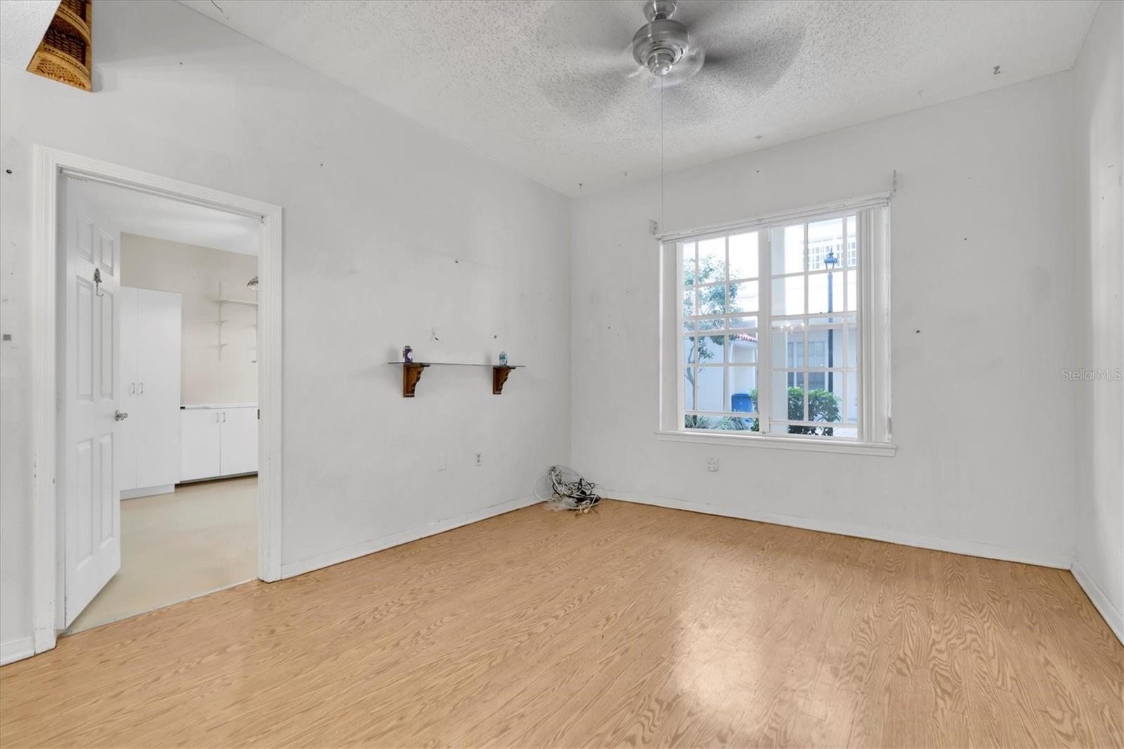 Living area has nice windows peeking out to the quiet courtyard. Door leads into primary bedroom