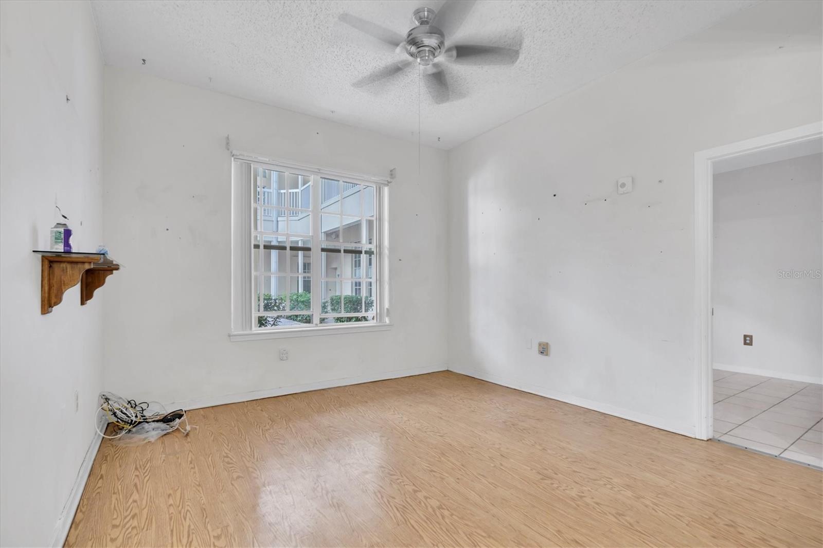 Another view of living area and outside courtyard view. Second bedroom on right