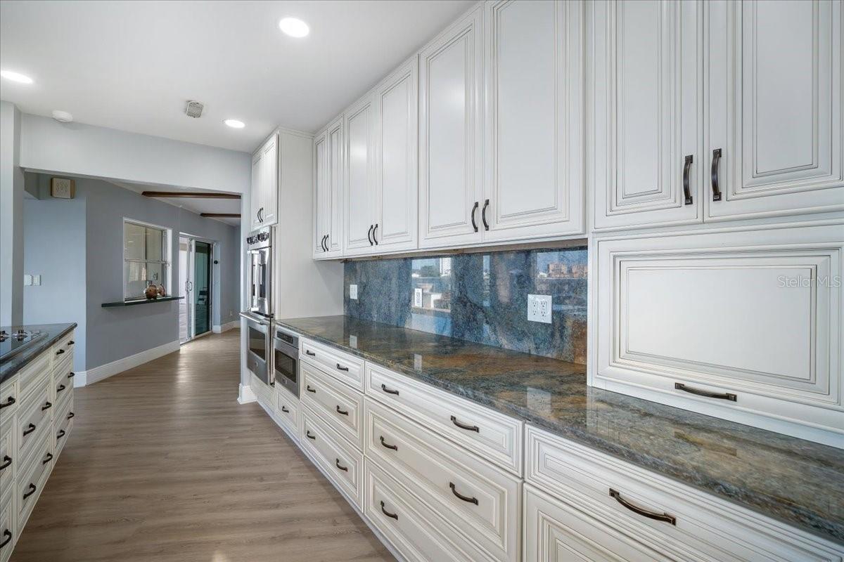This perspective of the kitchen provides you a different view of the enormous amount of cabinets and countertop space, showing its expansive and interconnected layout for a beautiful view and entertaining.