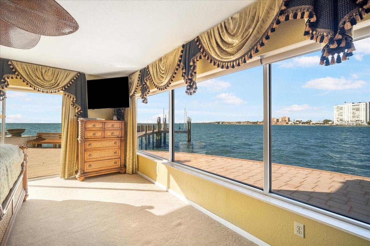 Presented here is another captivating view showcasing the master bedroom enveloped by serene water views.