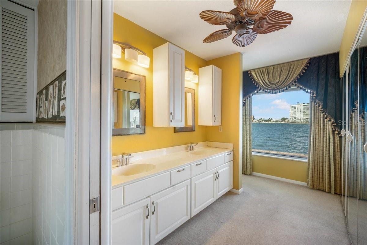 The master bathroom features dual sinks, plenty of cabinet space, and a captive water view from the en-suite.
