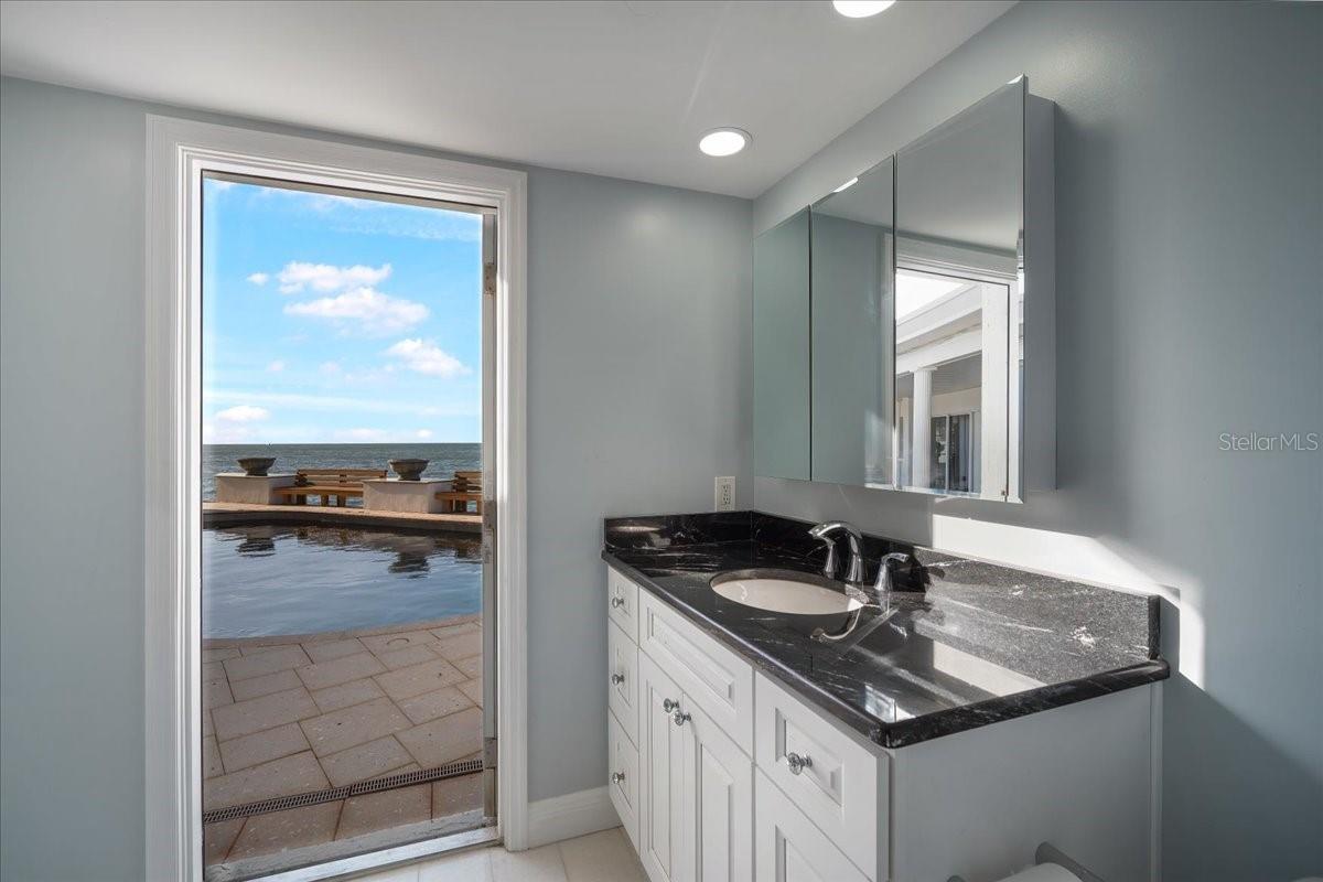 A recently renovated guest bathroom connecting to a guest bedroom as well as offering access to the inviting outdoor pool area and also access to the hallway for guests.