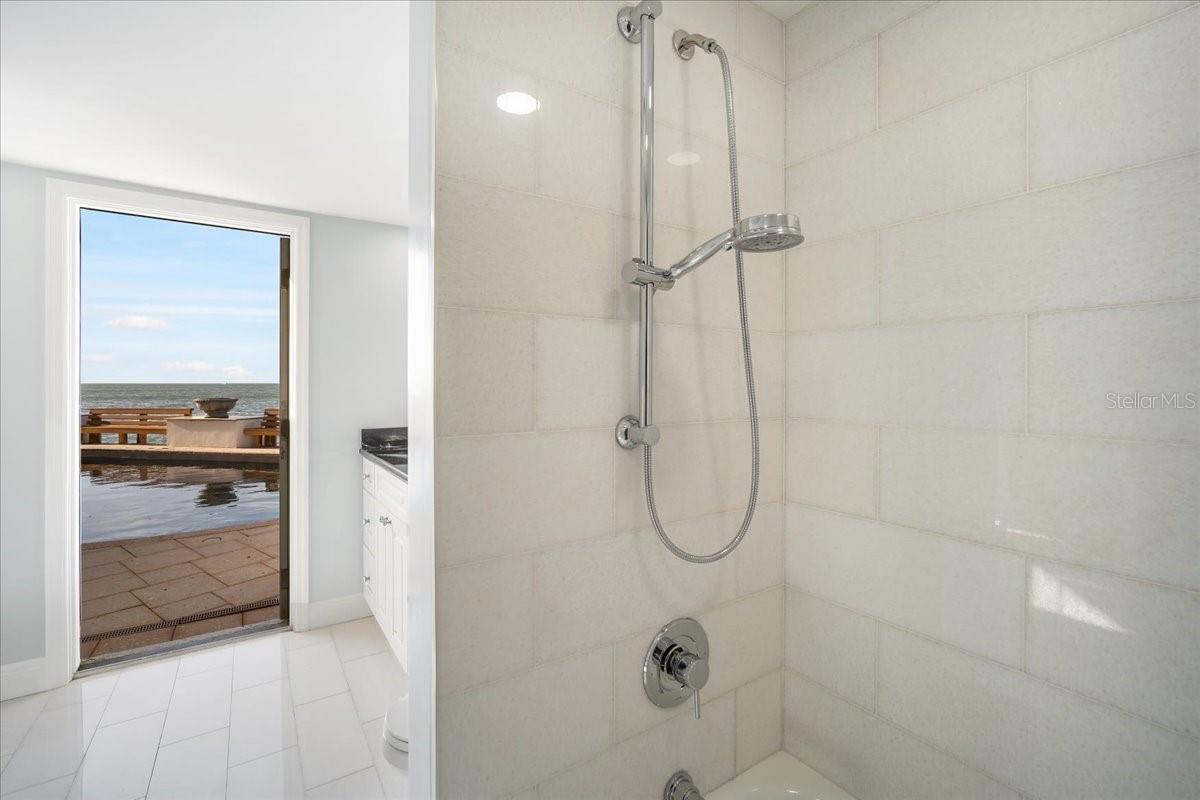 Guest Bathroom showing off the access to the pooi area. Newly renovated with modern newly tile.
