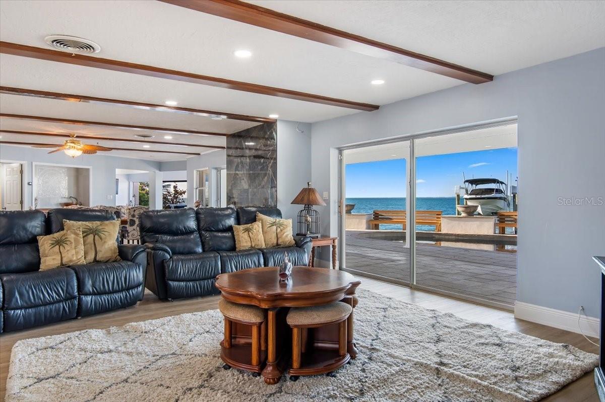 A closer view of the family room unveiling the rest of the stunning and spacious layout, accompanied by the captivating water view.