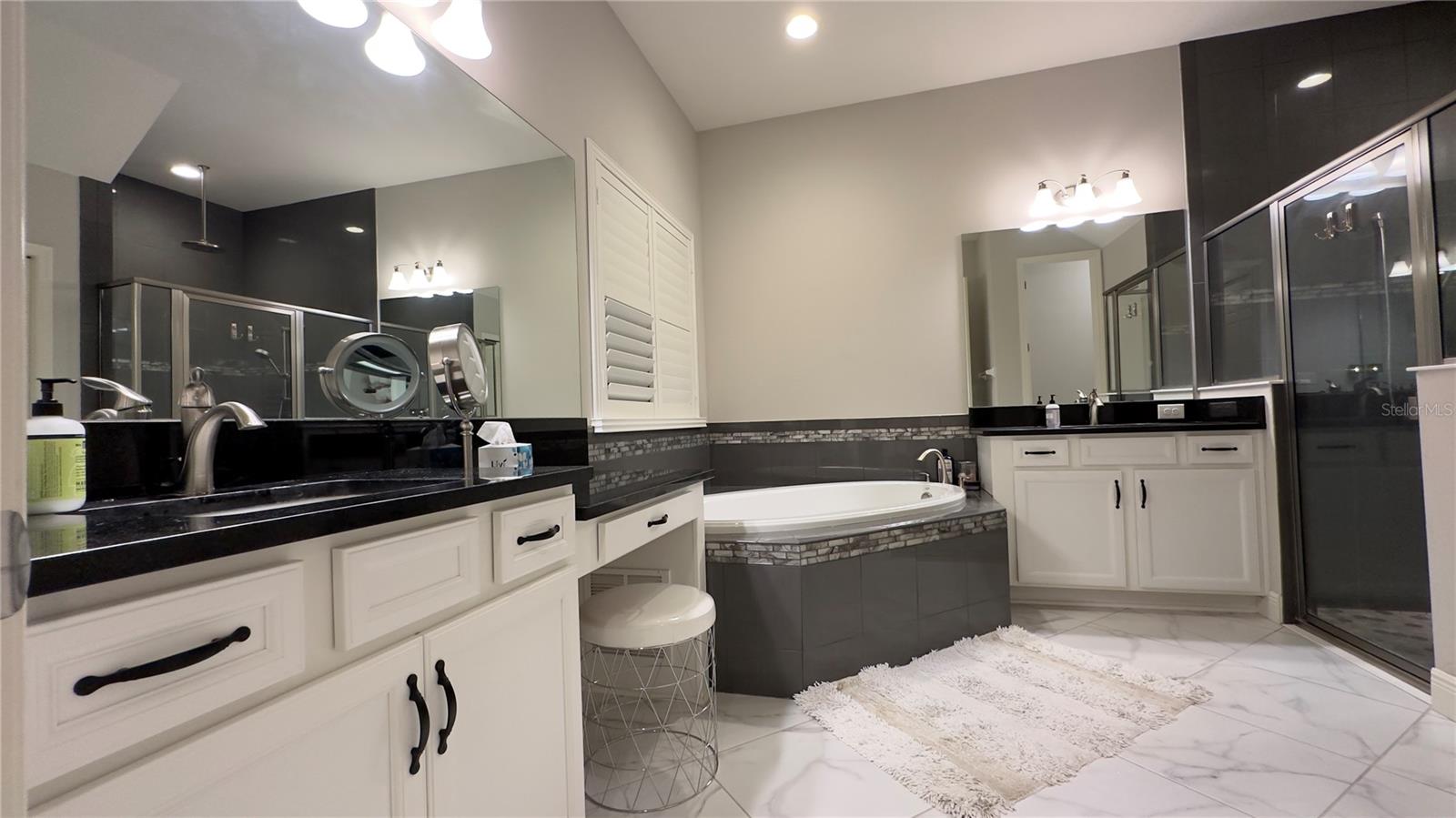 The luxurious Master bathroom is a heavenly refuge with its glamorous yet inviting black and whiteaesthetics. Granite counter tops, elegant light fixtures and brushed nickel faucets enhance the appeal ofthe garden tub, walk-in shower and double sink with vanity