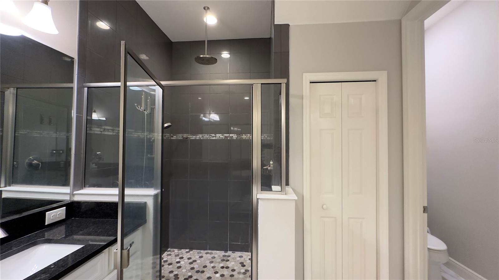 The large walk-in shower with combo rain showerhead and handheld shower wonderfully refreshes