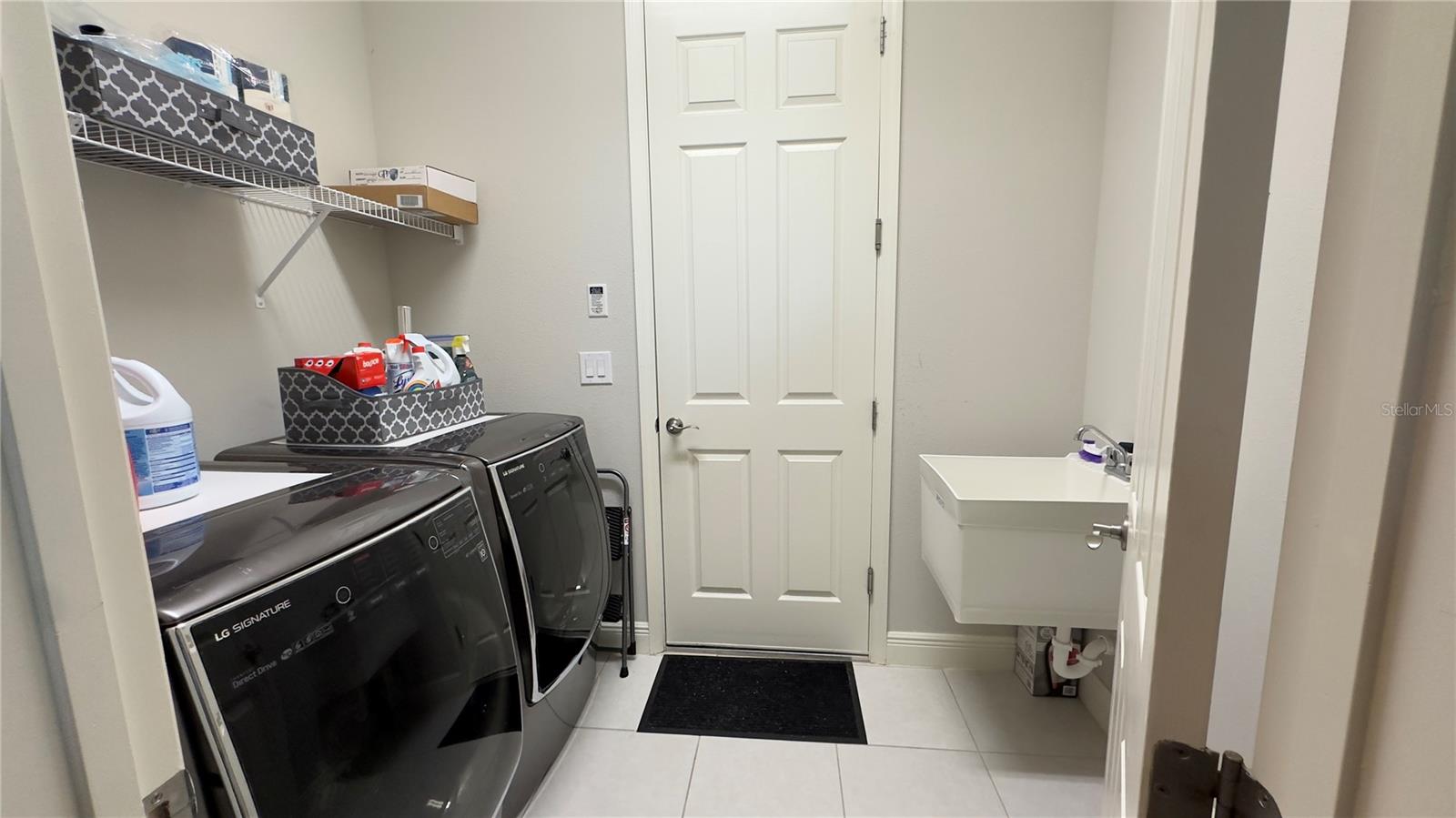 The spacious laundry room conveniently includes a tub and gives access to the garage