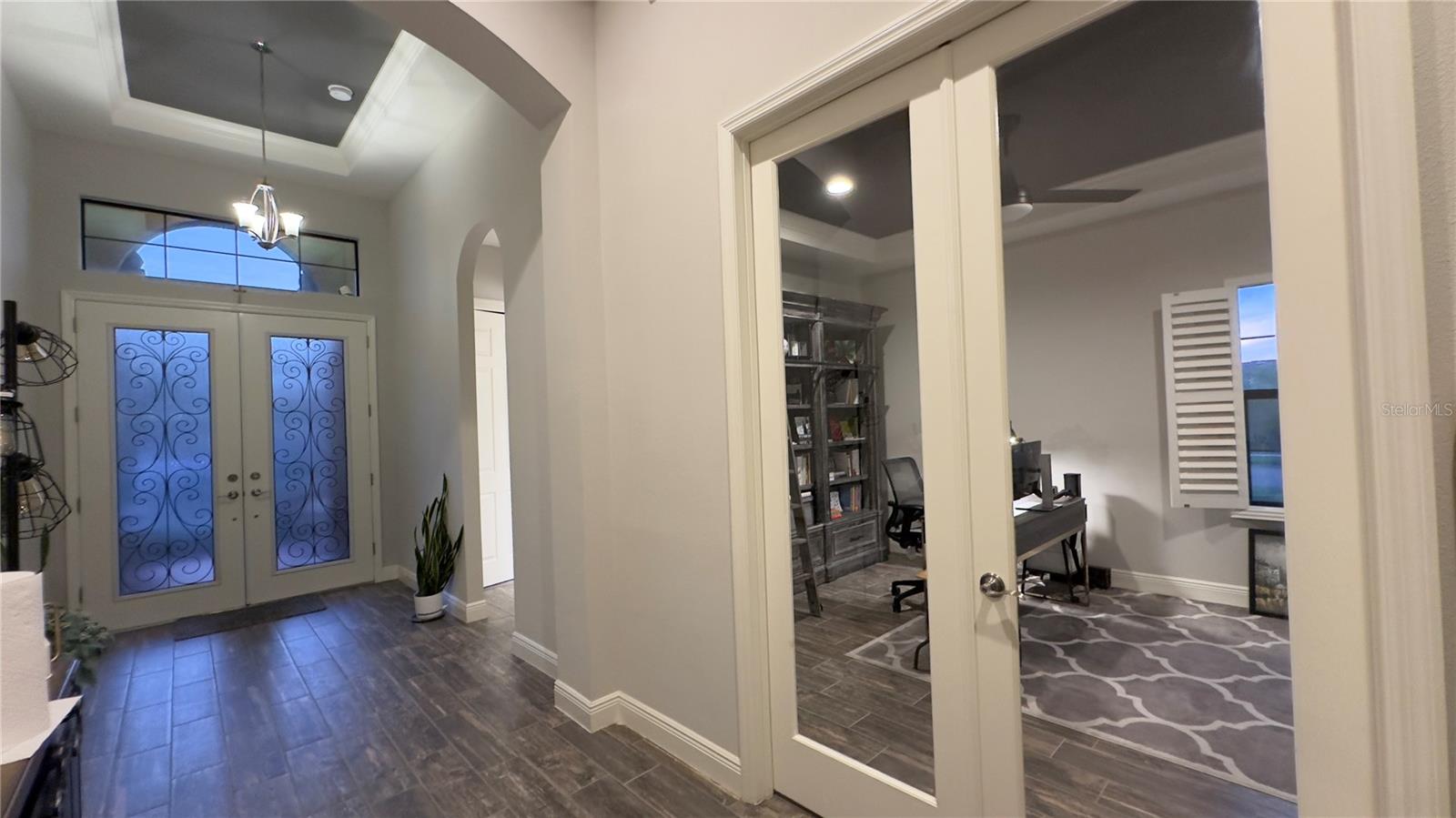 Further down the foyer, French doors give a peek to the Den/Office