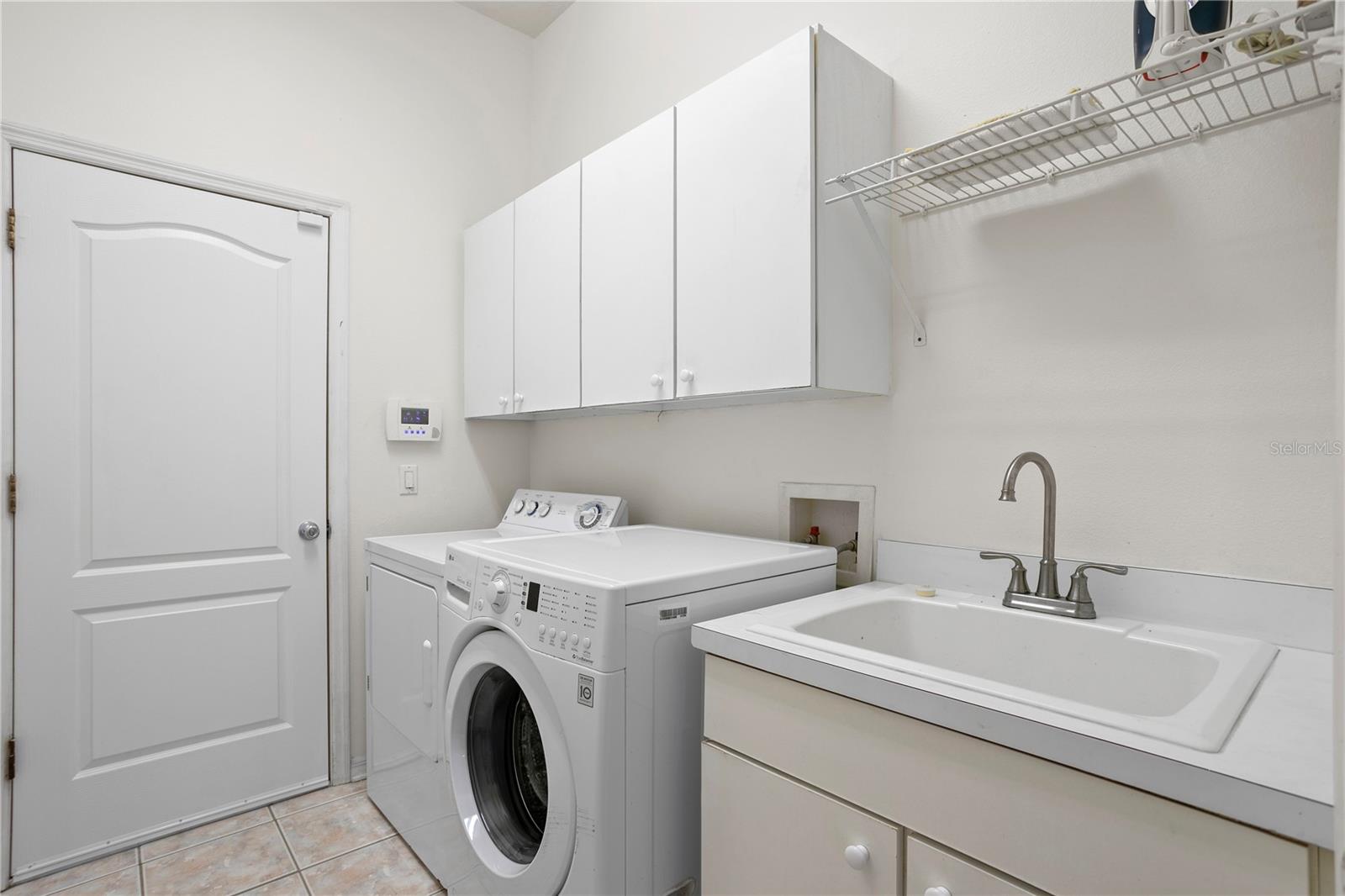 Spacious laundry room with utility sink and cabinetry