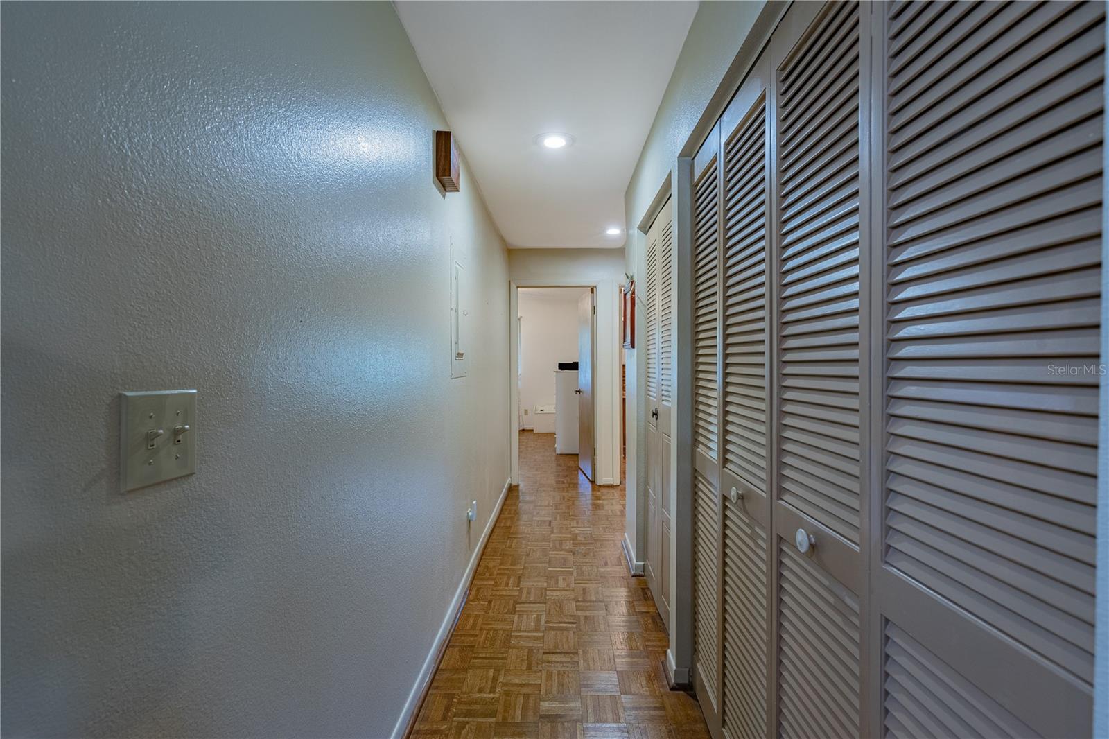 Hallway to guest bath and bedrooms.  Laundry closet doors are also shown here.