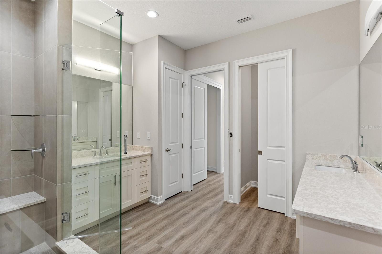 Main Bathroom featuring dual vanities, oversized shower, water closet, linen closet Kohler fixtures, soaking tub.