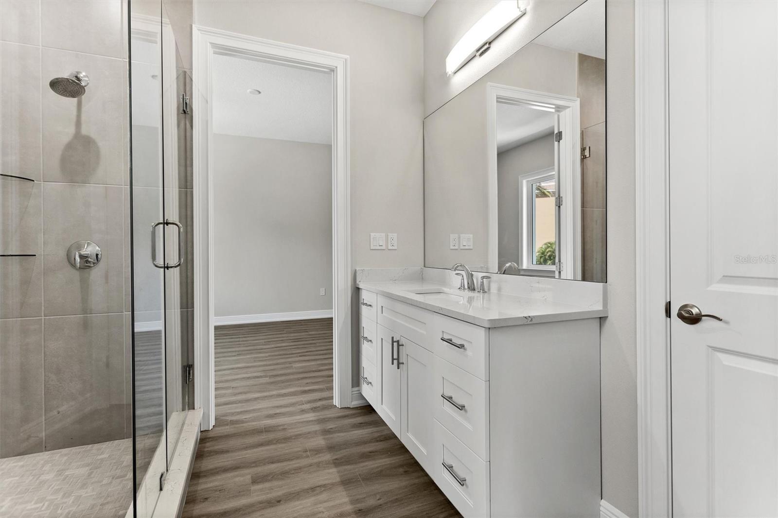 J&J Bath shared by Guest Bedroom #2 and #3, featuring a large shower, extra long vanity, and linen closet.