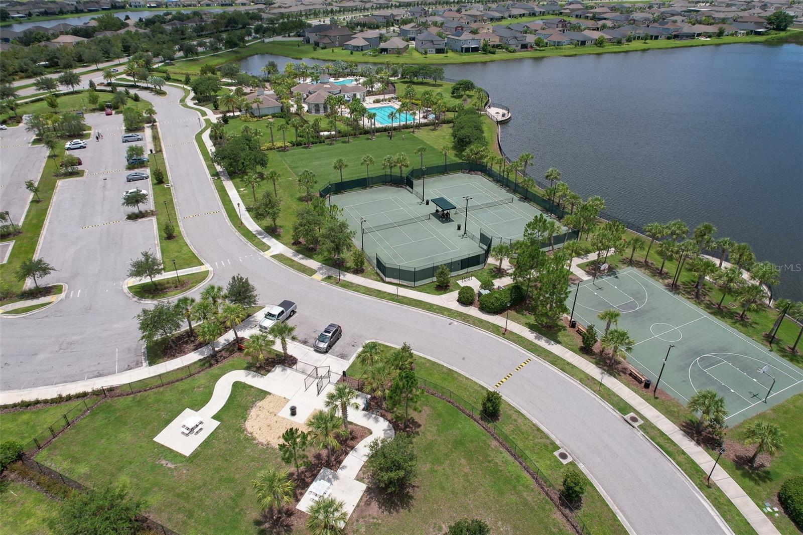 View of dog park, tennis courts, basketball court and turfed sports field.