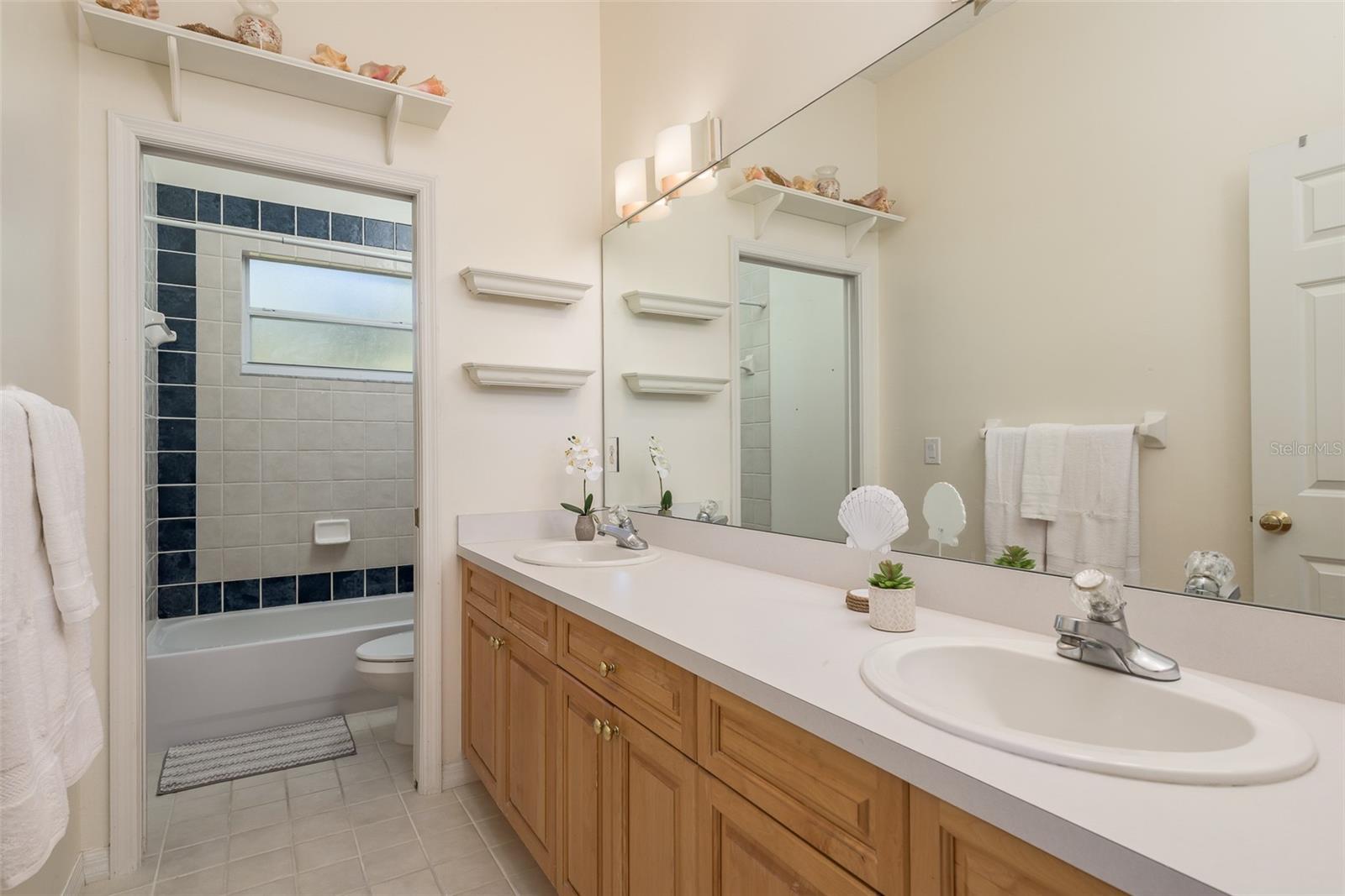 Bathroom 2 impresses with its generous size and practicality, featuring a spacious layout and dual vanity sinks, providing ample countertop space and storage for everyday essentials, ensuring convenience and comfort for all occupants.