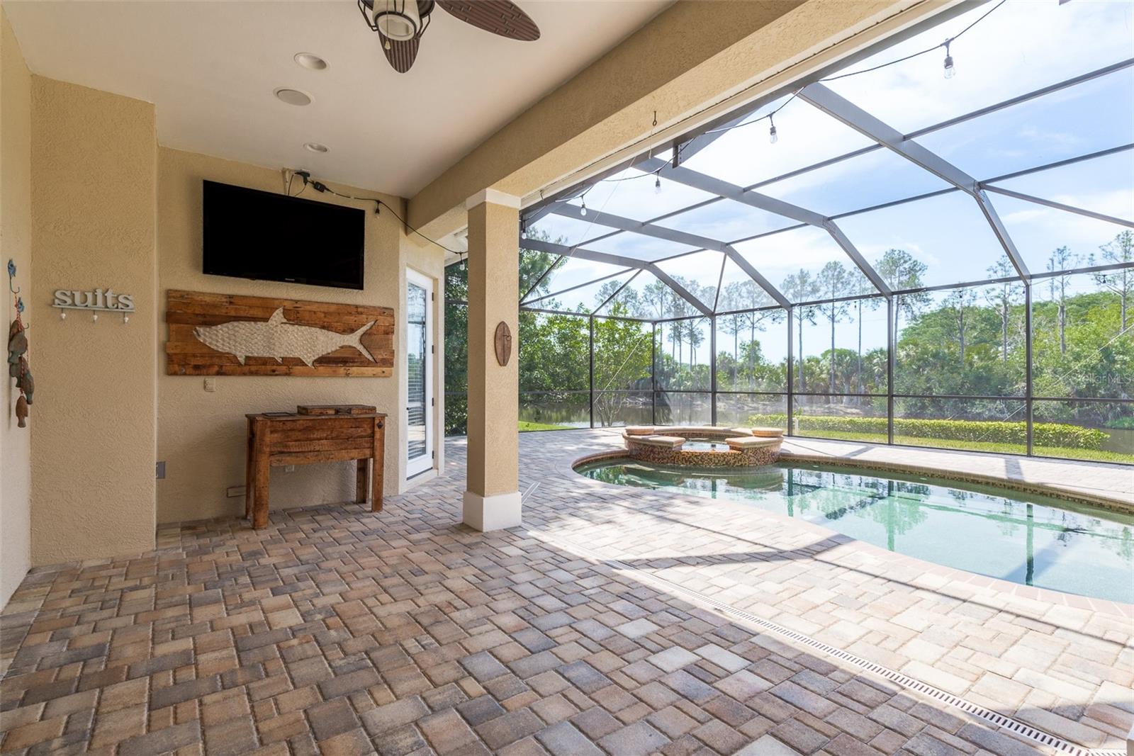 The patio and salt water pool area offer a tranquil retreat with breathtaking views of the serene pond, creating a picturesque backdrop for outdoor relaxation and entertainment, where every moment is infused with natural beauty and tranquility.