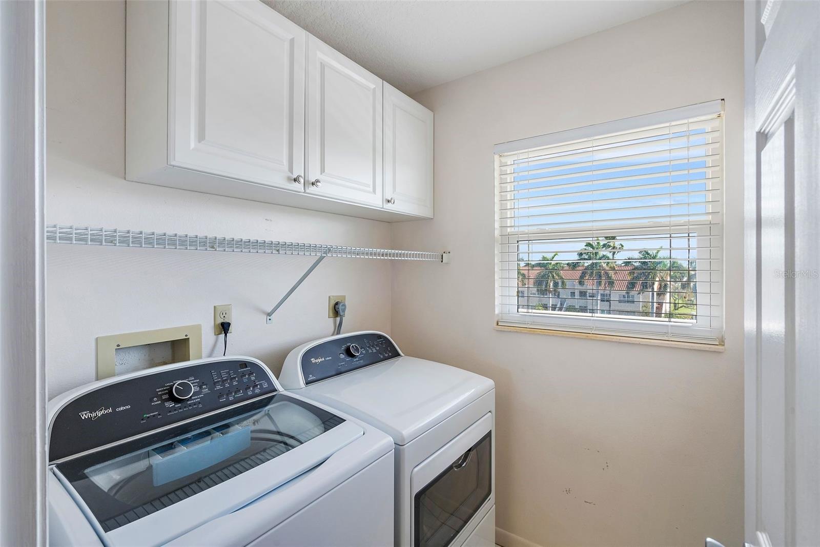 Door to the full-size laundry room with full-size washer and dryer.