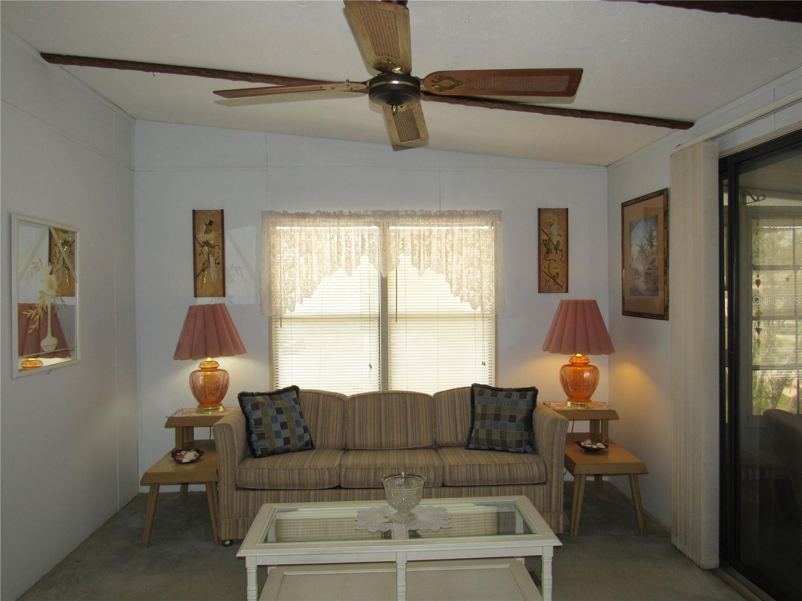 Living room with sliding glass door to raised Florida room.