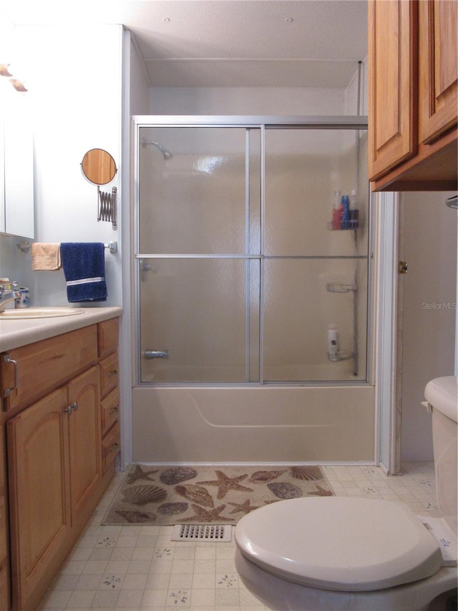 Bathtub & shower surround with sliding glass door.