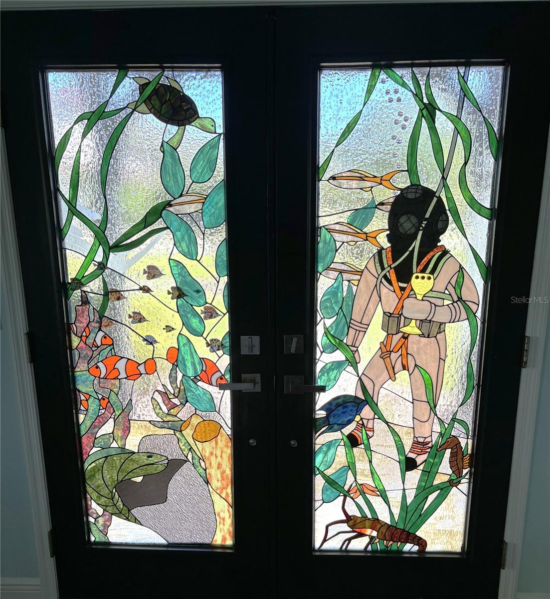 Custom stain glass door depicting sponge diver and underwater scene