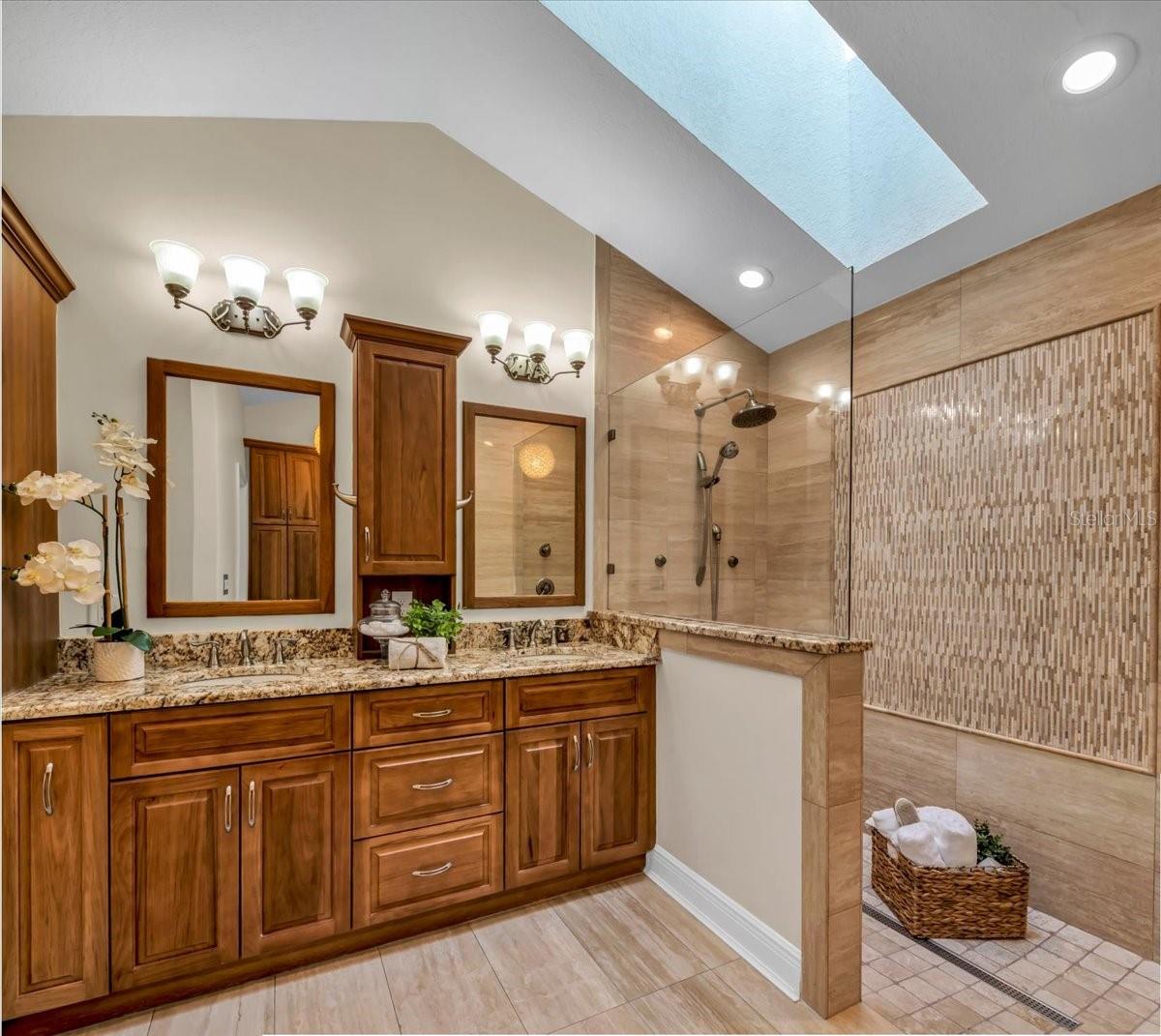 Primary bath with large walk-in shower, dual sink vanity and walk-in closets