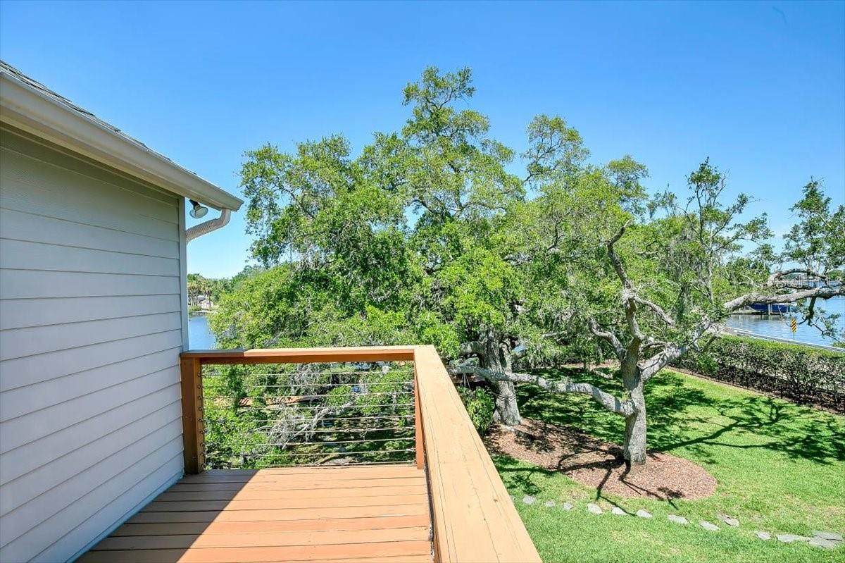 Deck overlooking two Grand oak trees, the canal and bayou