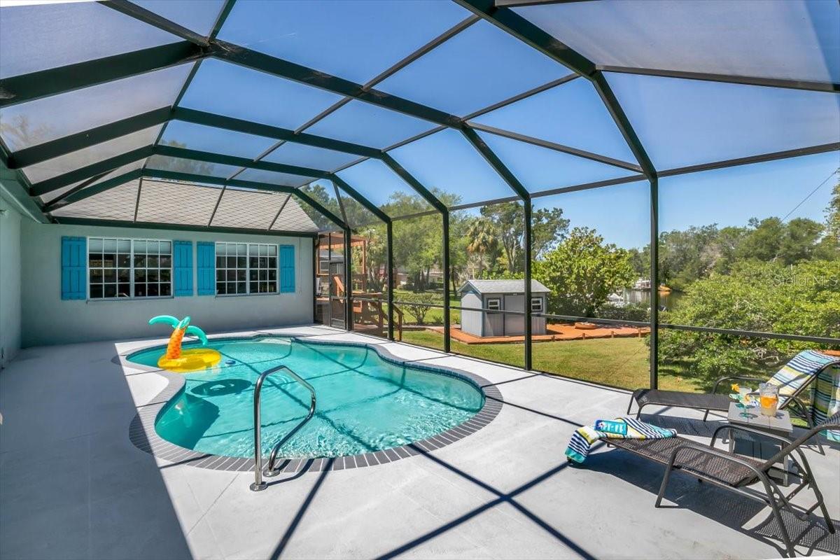 In-ground pool with screened pool enclosure