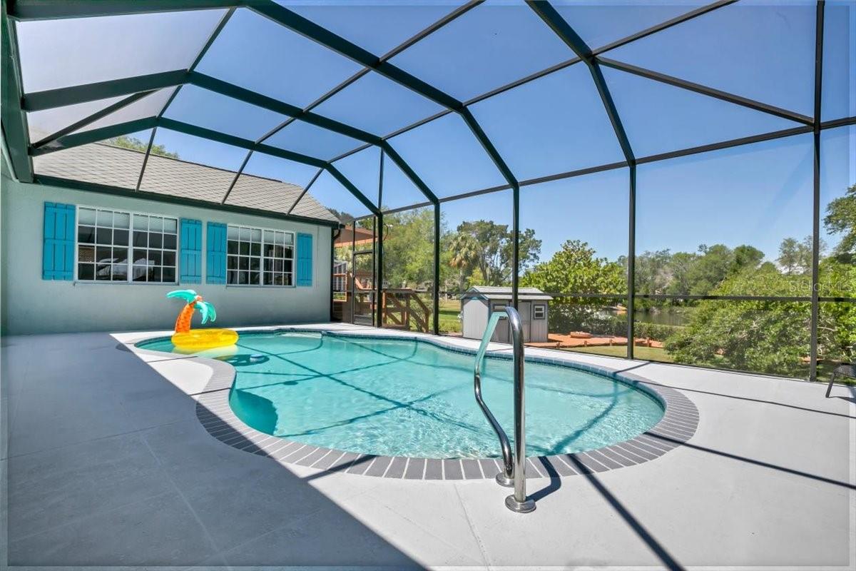 In-ground pool with screened pool enclosure
