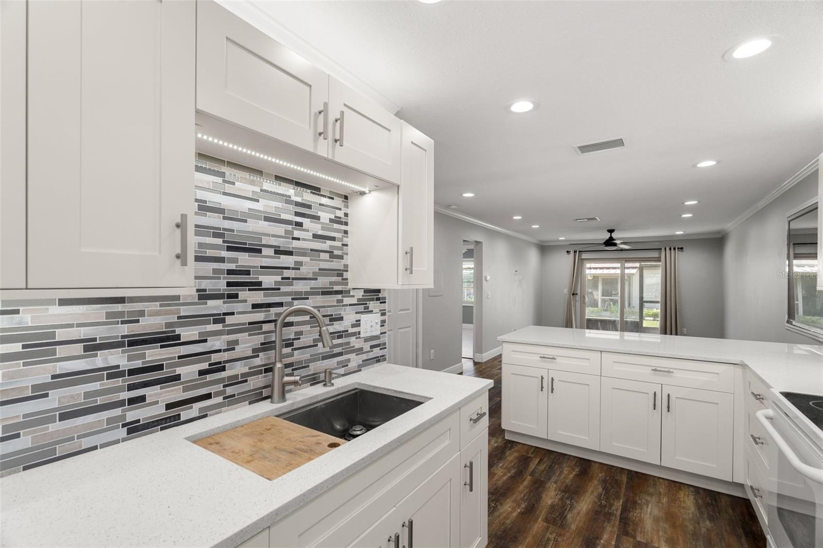 Notice how the under-cabinet lighting beautifully accentuates the backsplash tile. The 2nd bedroom is opposite the living room providing a split floor plan!