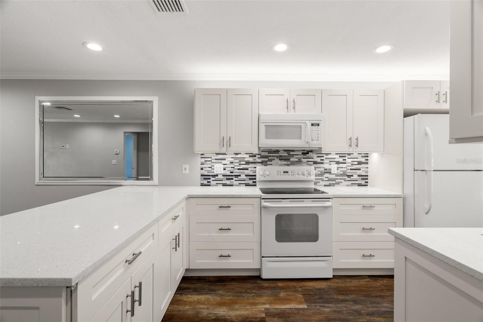 The fully updated kitchen features sleek shaker cabinets and a convenient layout of counters and appliances.