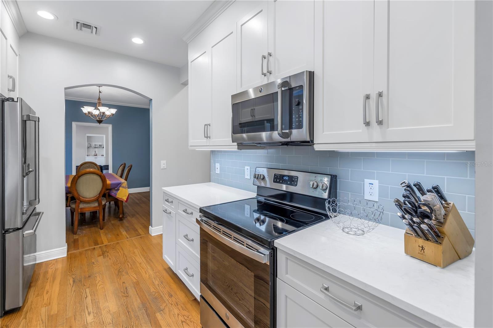 This exceptional kitchen boasts custom white cabinetry, quartz counters and a sizable pantry area.