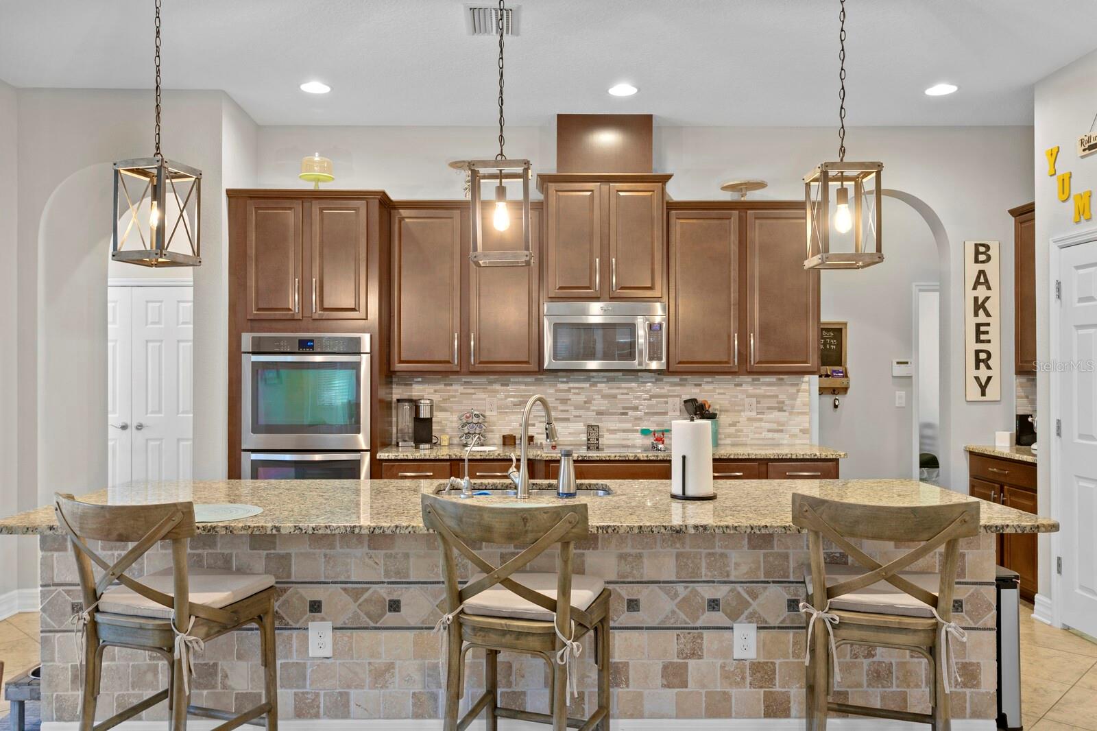 Kitchen features walk in pantry, 42" cabintry, pendant lighting, island, and double all oven.