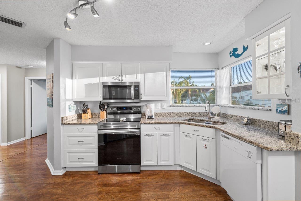 Stunning kitchen featuring ample cabinetry, stainless steel appliances, granite counter tops, and a dinette.