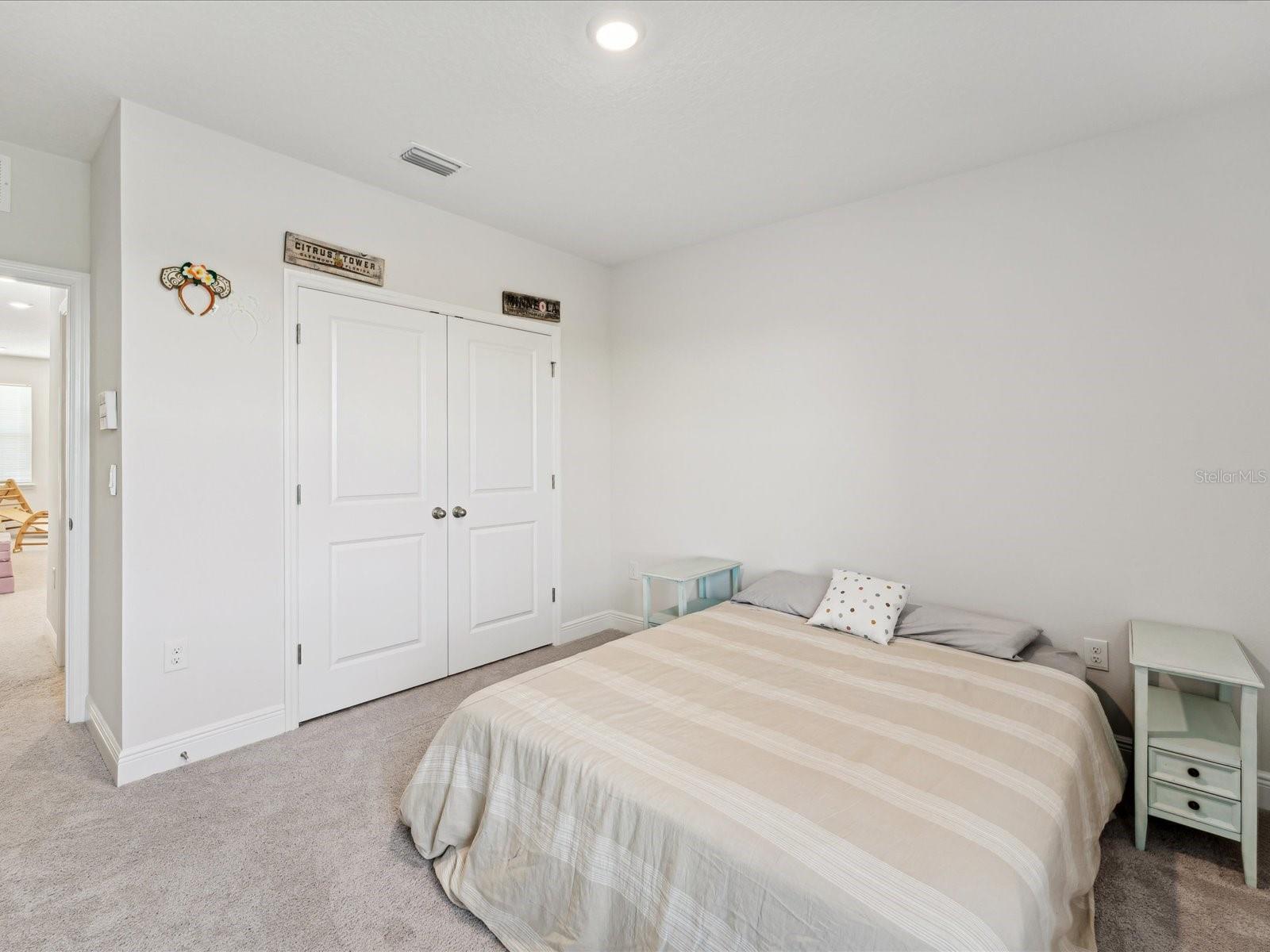 This bedroom has a double door closet and a a partially obscured entry.