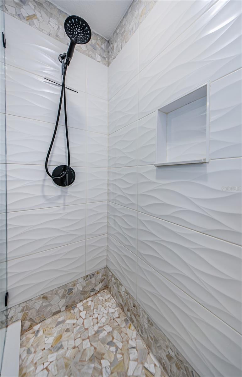 Primary bath shower with new custom tile work and glass door
