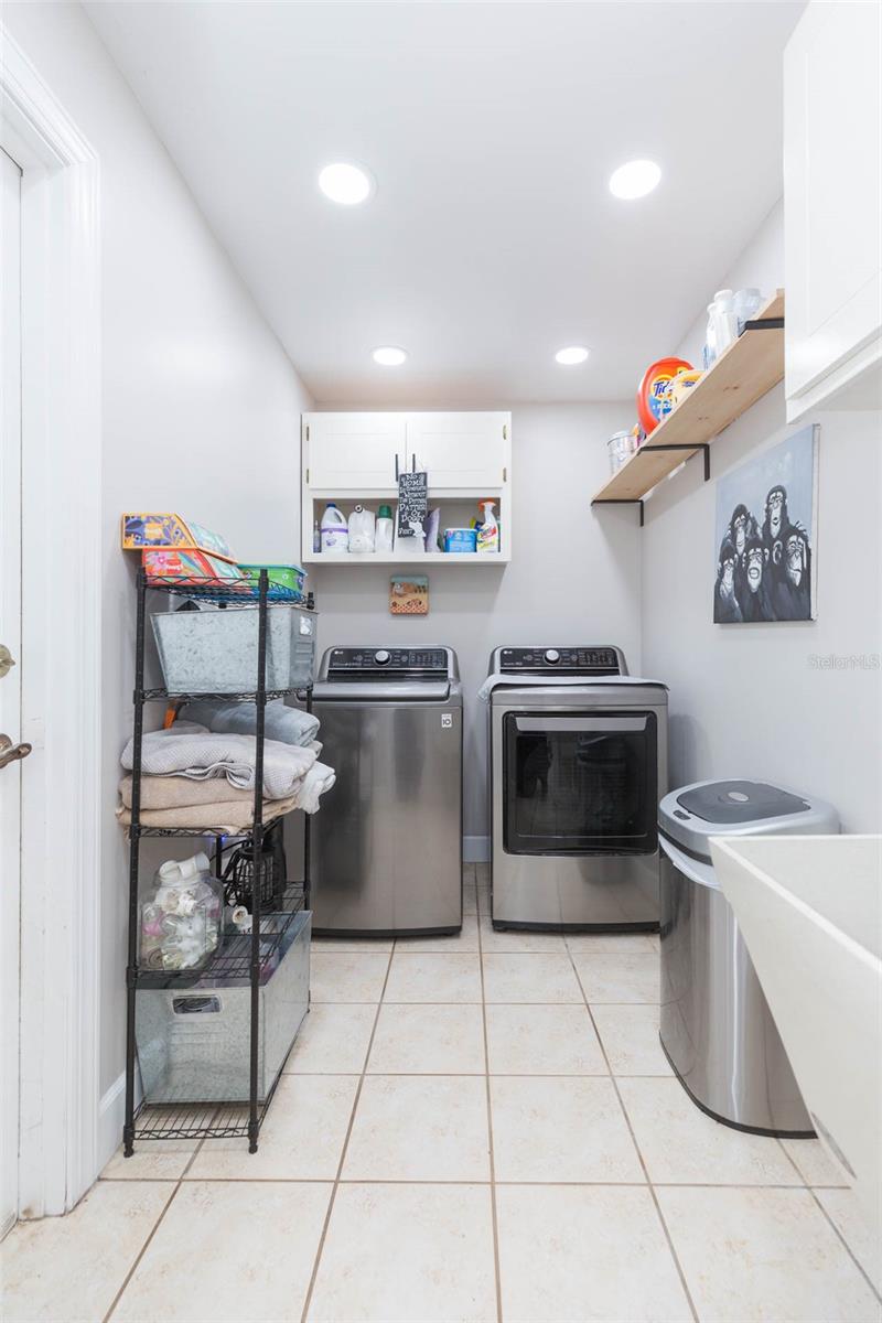 In-house laundry room with built in sink and cabinetry...