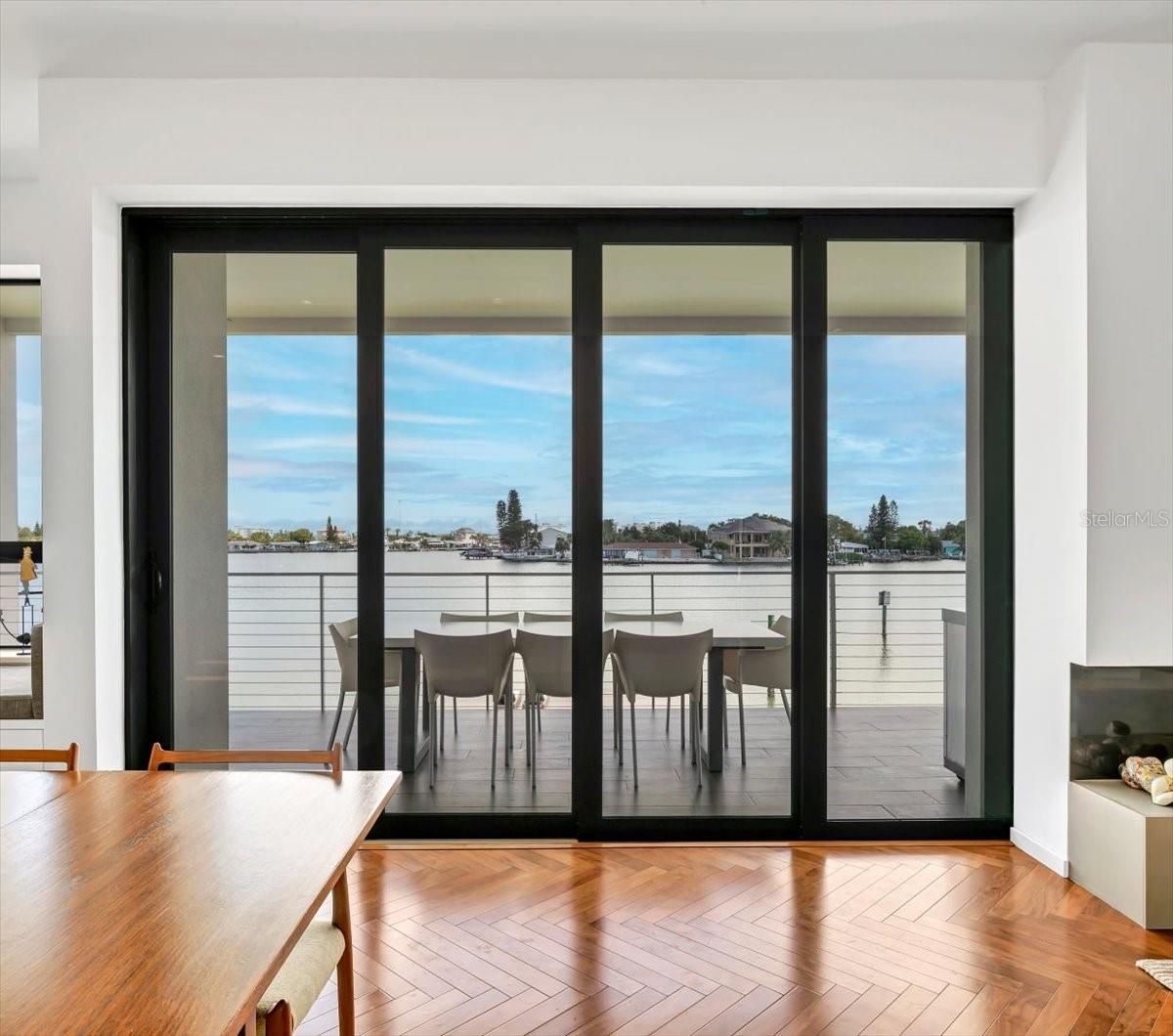 Pocketing sliding glass doors provide a view of the open covered deck and its outdoor dining space