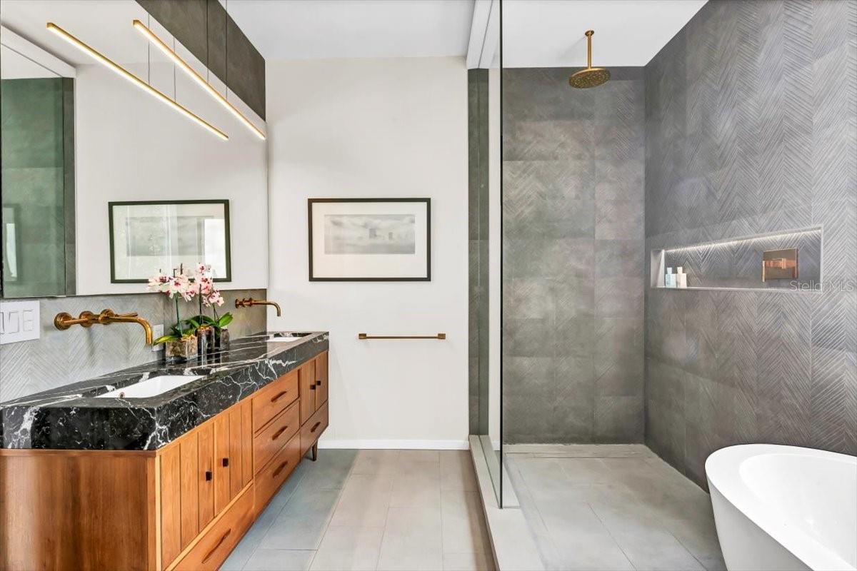 With dazzling tilework, offset LED lighting, rainshower, and double vanity built from a vintage credenza, you will love the scintillating and luxurious owner’s bath.