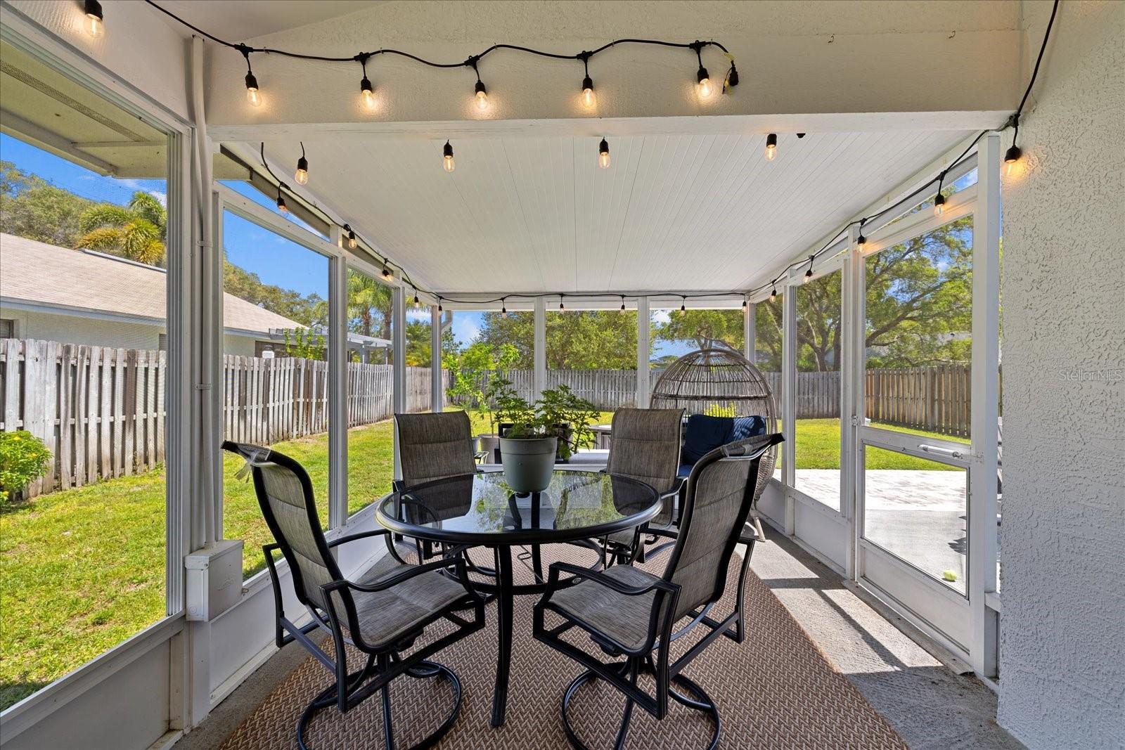 large screened lanai leads to oversized yard with uncovered patio